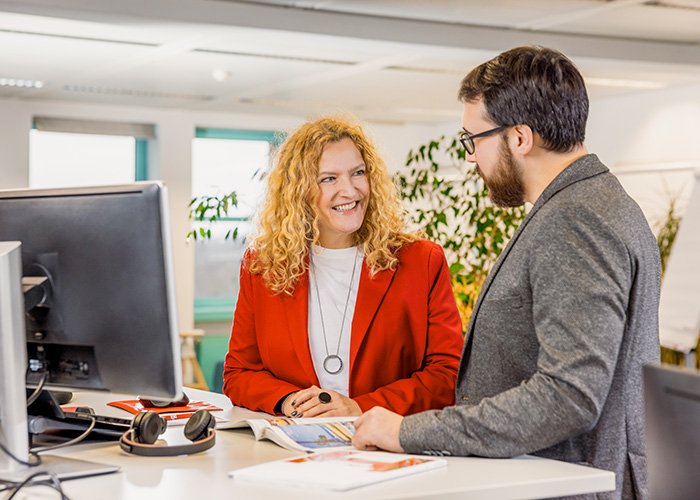 zwei Menschen beraten sich in einem Büro