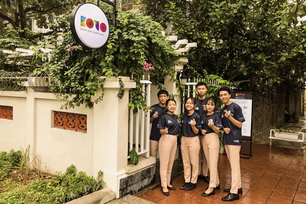 Gruppen von asiatischen Jugendlichen vor dem Cafe der KOTO Initiative in Hanoi, Vietnam