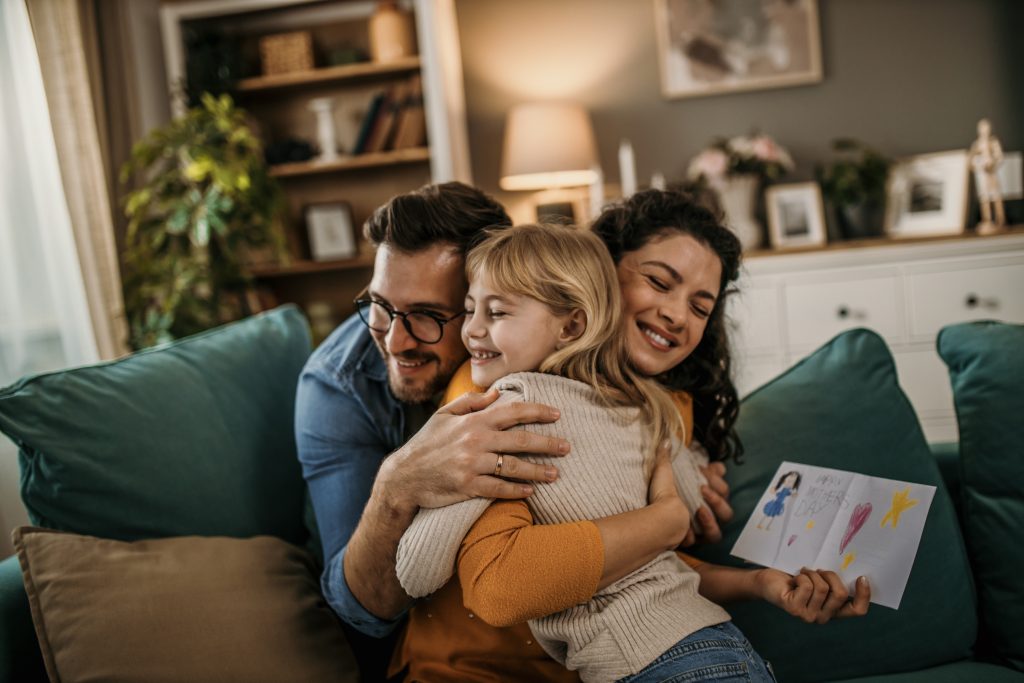 Vater und Tochter erleben einen rührenden Moment, als sie ihre Mutter in ihrem Wohnzimmer überraschen