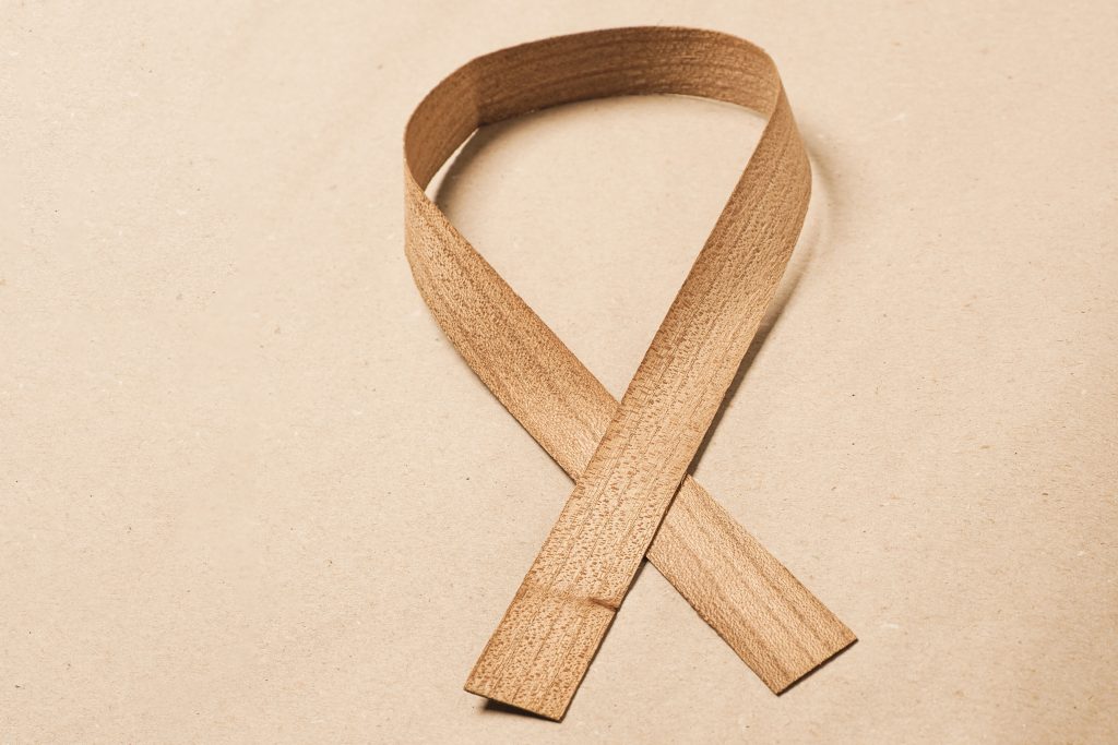 Holzkantenfurnier auf einem Naturpapier, Symbol für Leberkrebs