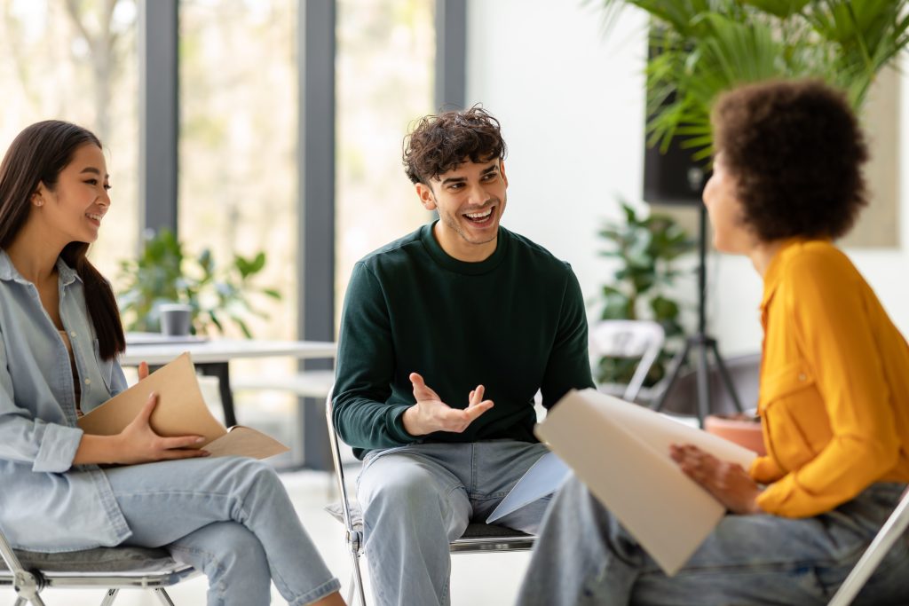 Konzept der Teamarbeit. Internationale Studenten, die in einem Coworking Space gemeinsam über ihr Bildungsprojekt diskutieren