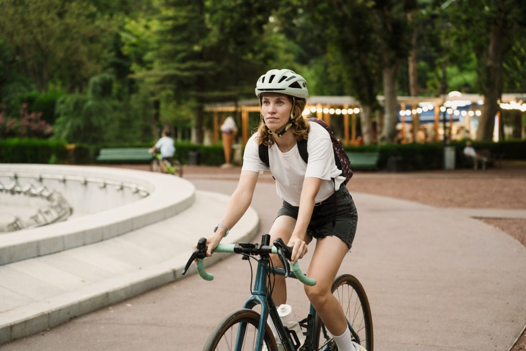 Frau mit Rucksack beim Radfahren im Park